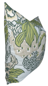 Square pillow cover with large floral pattern in muted green, cream, and soft blue on a white background, angled to show its front and one side.