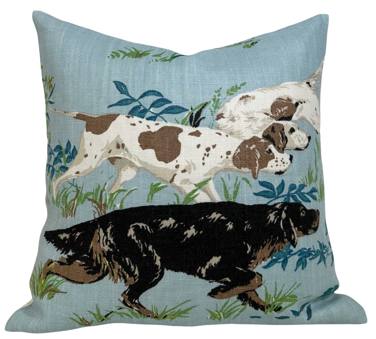 Square pillow cover with blue background featuring an embroidered design of three hunting dogs—one black and two white with brown patches—amid grass and plants.
