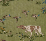 Patterned fabric with a standing bird hunting dog and flying ducks on a textured meadow green background with grass and foliage details.