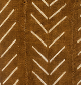 Close-up of brown mudcloth fabric with white chevron pattern arranged in vertical stripes, showing stitching details of the textile.