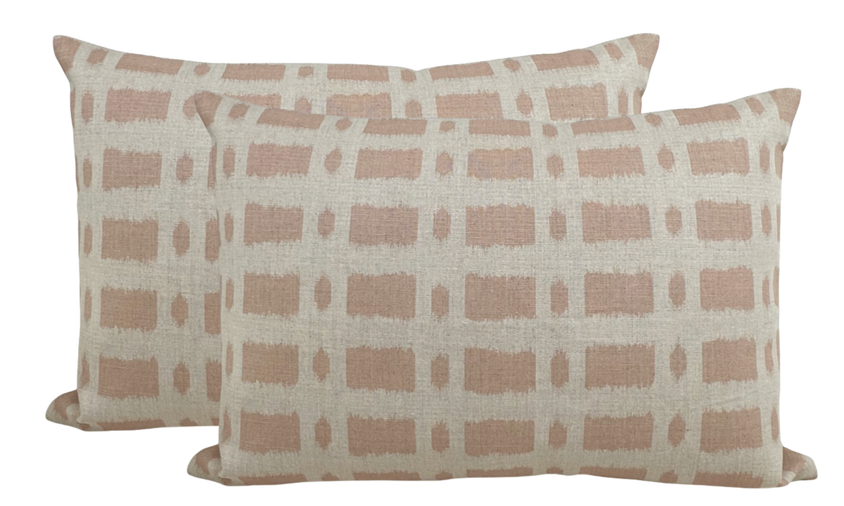 Two rectangular pillows with a pink grid pattern of short horizontal and vertical brushstroke lines on an off-white fabric background, shown side by side.