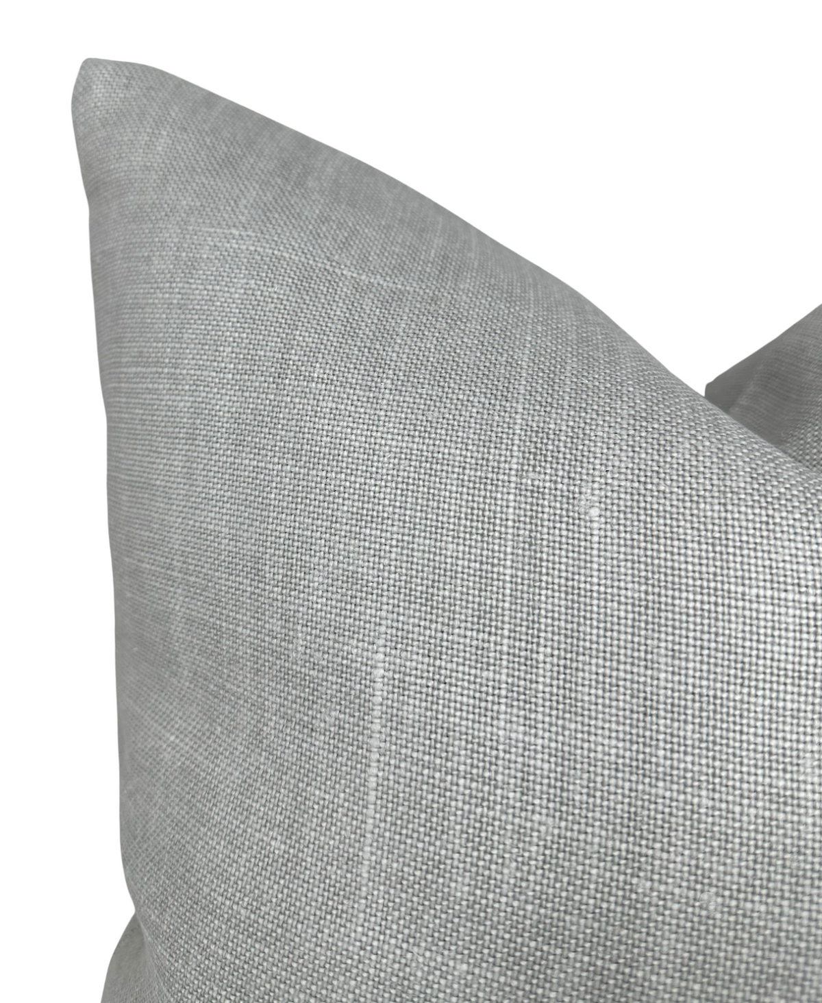 Close-up of a soft gray linen pillow cover with a subtle woven texture, shown against a white background highlighting its fabric detail.