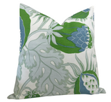 Square pillow cover featuring a botanical pattern with large green and blue leaves and soft gray stems on a white background, angled to show depth and fabric texture.