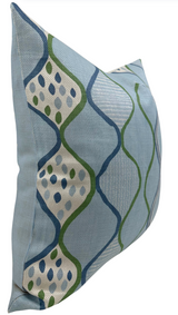 Rectangular pillow cover in pale blue fabric with a woven geometric pattern of curved blue and green lines enclosing dotted white diamond shapes.