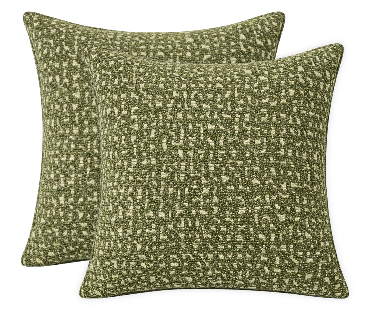 Pair of square pillow covers in chive green with textured, irregular pixelated pattern on a beige background.