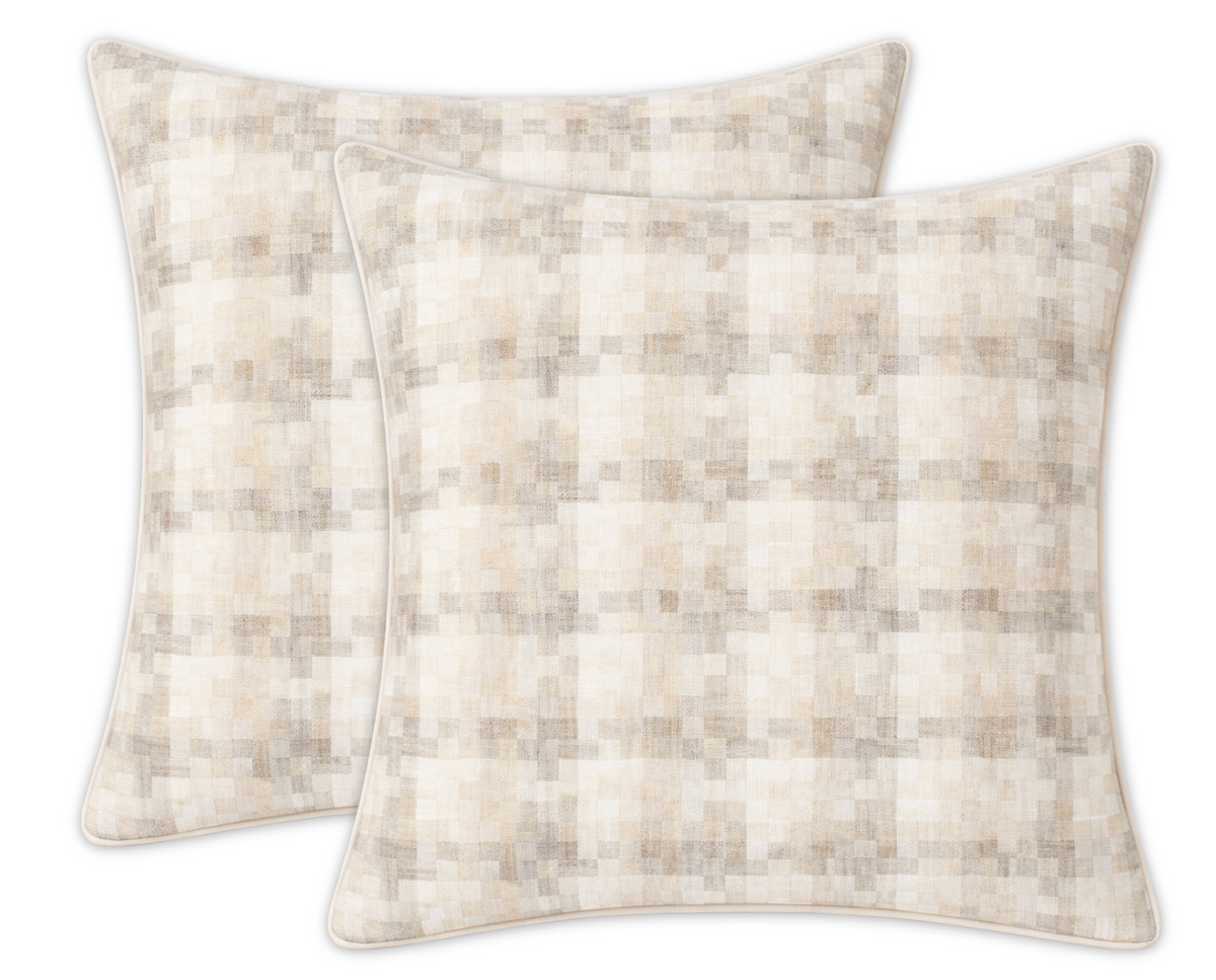 Two square pillow covers featuring a subtle woven check pattern in soft natural beige and cream tones with piped edges, arranged slightly overlapping on a white background.
