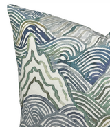 Close-up of a pillow cover showing an abstract pattern of flowing, wavy lines in shades of green, blue, and gray on a light background.