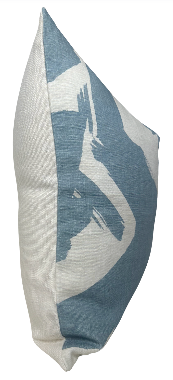 Side view of a linen pillow cover featuring bold, irregular blue brushstroke patterns on a white background, emphasizing texture and a relaxed rectangular shape.