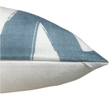 Close-up of a linen pillow cover with a blue and white abstract bold line pattern and a visible zipper on the side seam.
