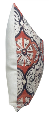 Square pillow with a bold ruby red background featuring white and black floral and circular patterns, contrasted by a plain off-white fabric on the side.