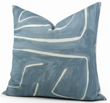 Square pillow cover in muted sky blue with an abstract white linear pattern resembling brush strokes across the fabric.