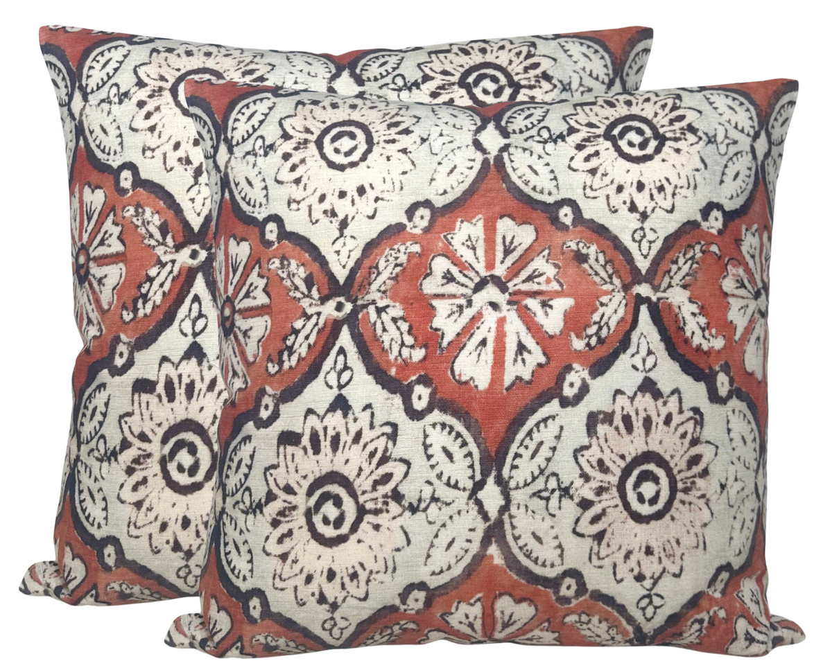 Pair of square pillow covers with floral and geometric pattern in ruby red, cream, and black, displayed side by side.