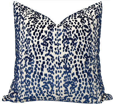 Blue velvet pillow cover with ivory linen back on a sofa