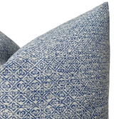 Close-up of a pillow cover with an indigo blue Sarong weave pattern featuring repeating geometric and floral motifs on a light background.