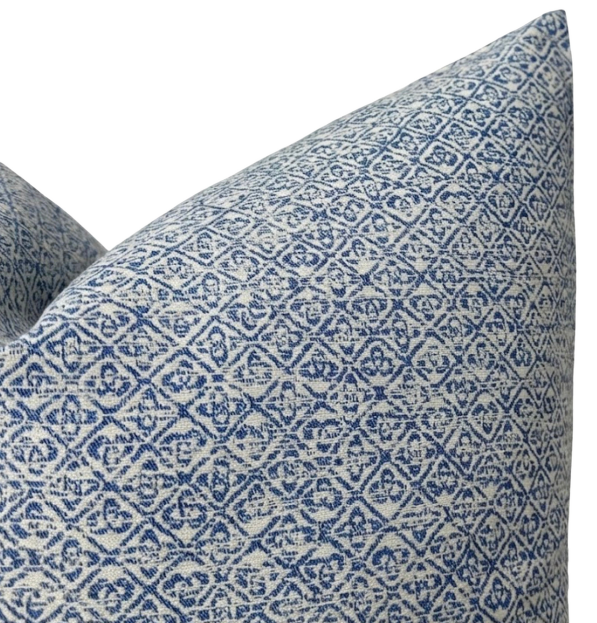Close-up of a pillow cover with an indigo blue Sarong weave pattern featuring repeating geometric and floral motifs on a light background.