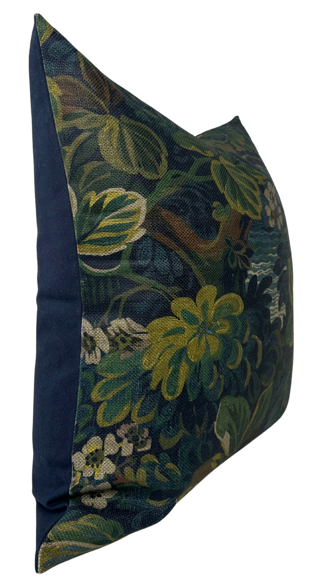 Square pillow with a floral pattern in dark green, yellow, and blue on the front, and solid midnight blue fabric on the side panel, shown from an angled side view.