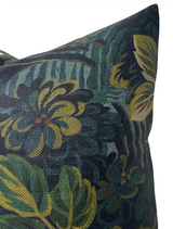 Close-up of a pillow cover featuring a midnight blue background with green and mustard yellow floral and leaf patterns in a textured fabric.