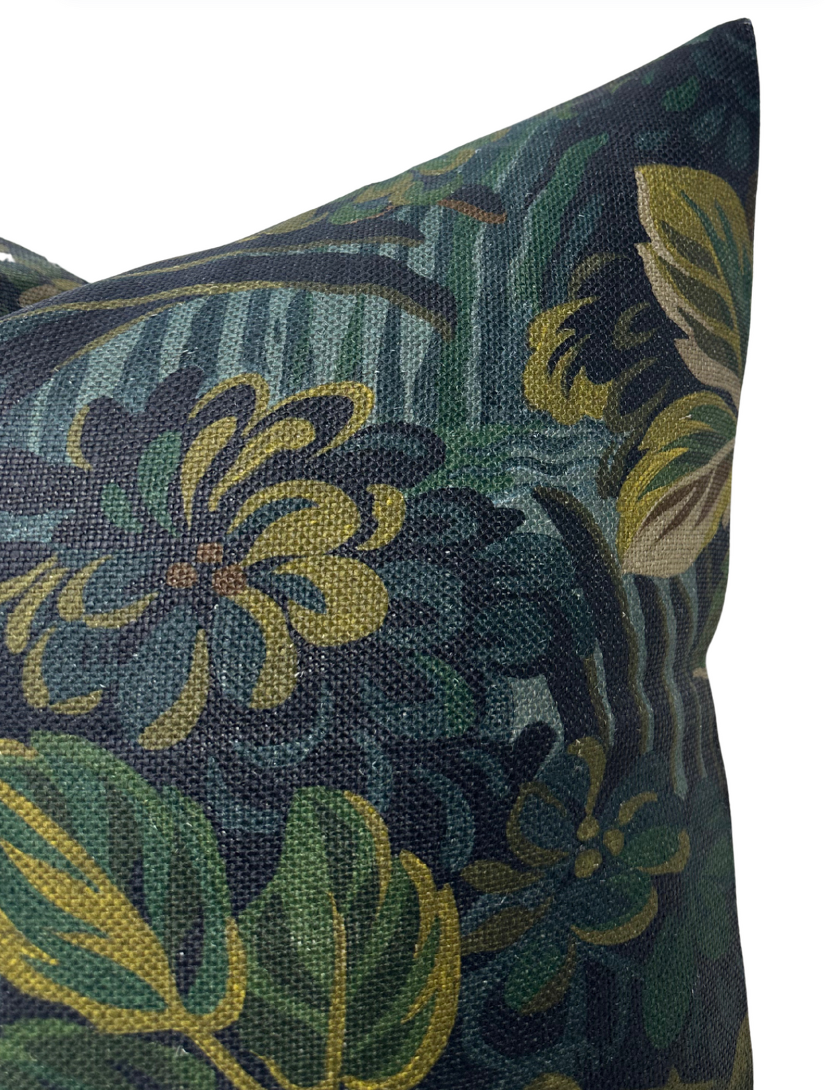 Close-up of a pillow cover featuring a midnight blue background with green and mustard yellow floral and leaf patterns in a textured fabric.