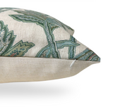 Close-up of a beige pillow corner featuring a sage green and muted blue floral pattern with a hidden zipper along the seam