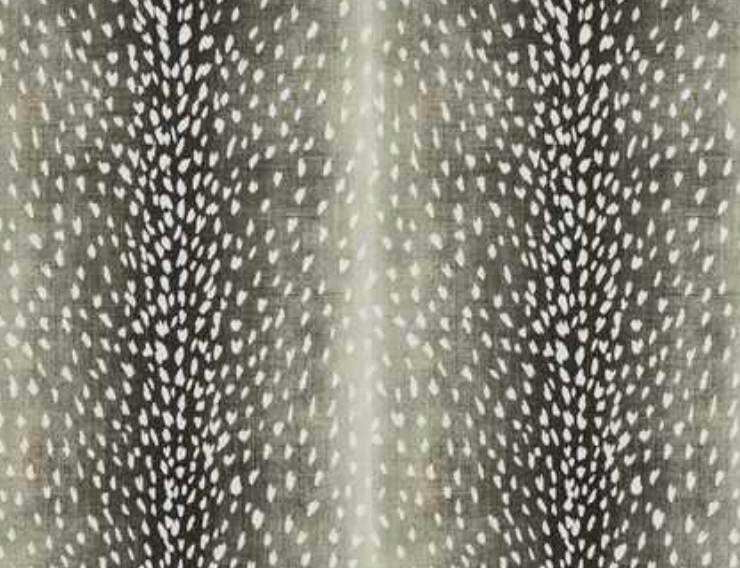 Close-up of a charcoal-colored pillow cover featuring a pattern of small white teardrop shapes arranged symmetrically in vertical stripes.