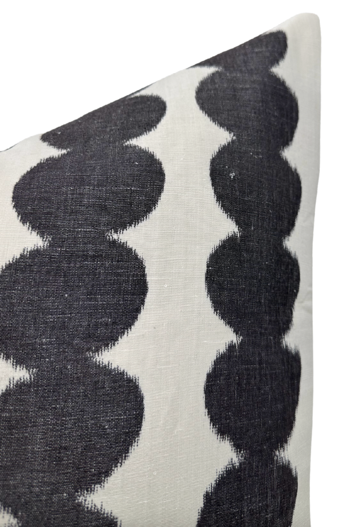 Close-up of a white pillow cover featuring two vertical rows of repeating rounded black shapes with a slightly faded texture on the fabric.