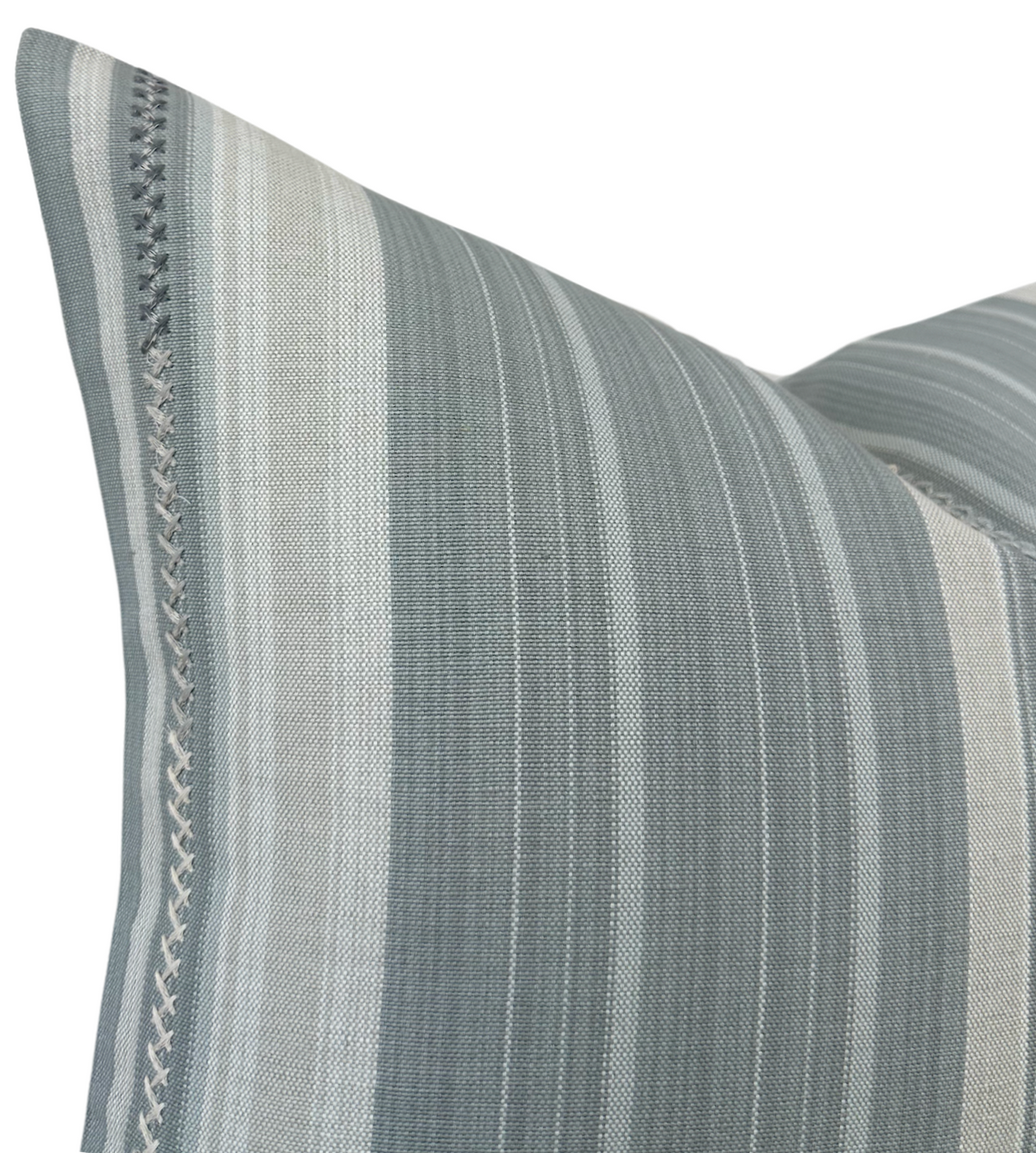 Close-up of a grey Barodo pillow cover with vertical stripes in varying shades of grey and beige, featuring a decorative stitched border detail.