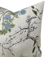 Rectangular pillow with beige background featuring detailed botanical print of blue and purple flowers, white berries, and green birds perched on thorny branches.