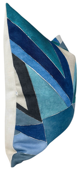 Square pillow cover featuring an abstract geometric pattern in shades of navy, teal, light blue, and black on a beige background, shown from a side angle.