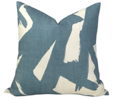 Square pillow with sky-blue linen fabric and bold irregular white brushstroke patterns creating an abstract, artistic design.