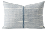 Rectangular pillow cover with light blue and white woven pattern featuring small dots and diamond shapes, centered zip closure with blue trim detailing.