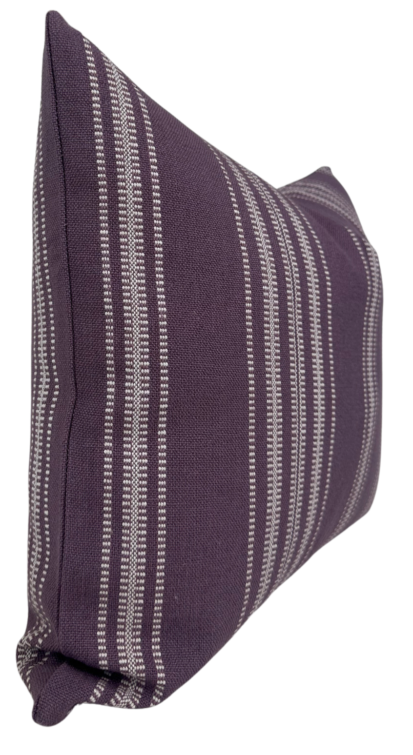 Rectangular royal purple pillow cover with vertical white Mayan-inspired stripes, shown from a side angle highlighting its soft fabric texture and clean edges.