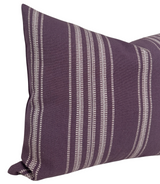 Close-up of a royal purple pillow cover featuring vertical white Mayan-inspired striped patterns on woven fabric.