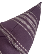 Close-up of a deep purple pillow cover featuring horizontal white Mayan-inspired stripe patterns and a central seam detail.