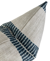 Close-up of an indigo and beige woven band pillow cover with geometric stripe patterns converging at a corner seam, showing textured fabric detail.