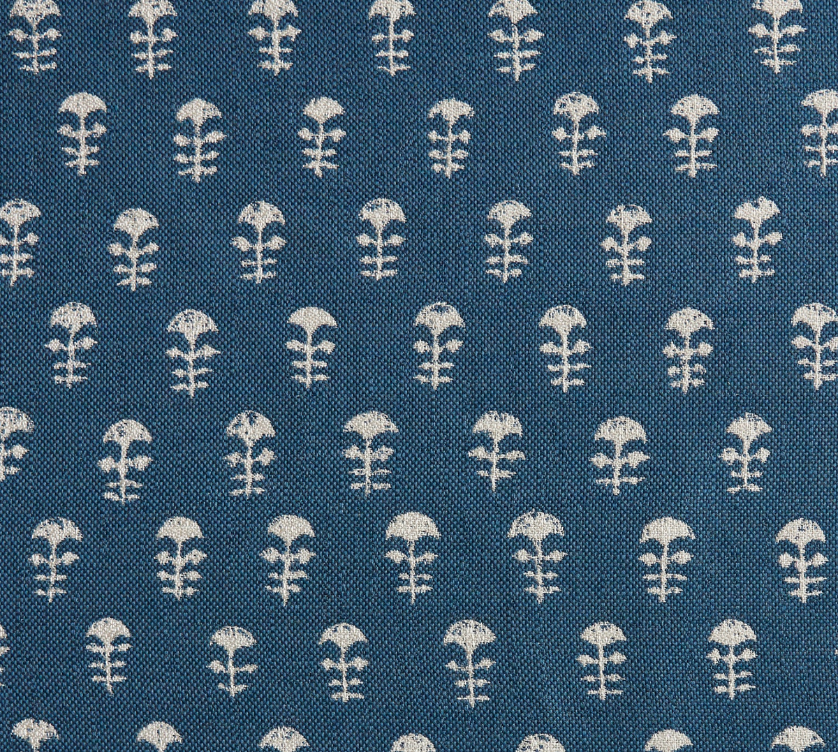 Close-up of Yukka Woven Pillow Cover fabric in Atlantic Blue with small white floral motifs arranged in rows over textured weave.