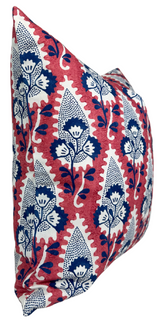 Square pillow with red background and stylized white and navy blue floral motifs in vertical rows, shown from a side angle.