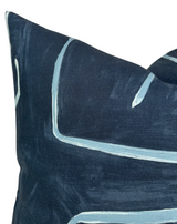 Close-up of a navy blue Graffito pillow cover featuring hand-painted pale blue linear accents on textured fabric.