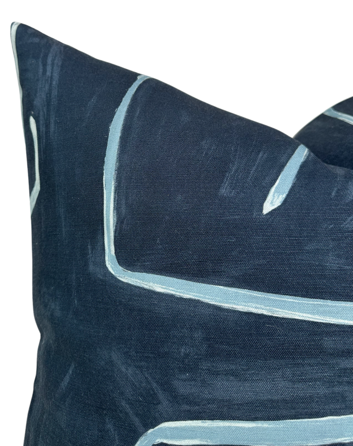 Close-up of a navy blue Graffito pillow cover featuring hand-painted pale blue linear accents on textured fabric.