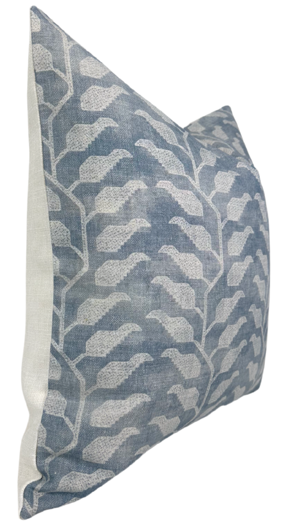 Square pillow with lake blue fabric featuring a light beige geometric leaf pattern, shown at a slight angle highlighting its texture and side seam.