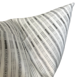 Close-up of a charcoal and white pillow cover with thin, irregular horizontal stripes and subtle geometric motifs by Susan Connor Textiles.