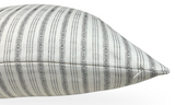 Close-up of a white pillow with evenly spaced vertical charcoal stripes featuring intricate geometric patterns, showing the clean stitched edge and pointed corner.