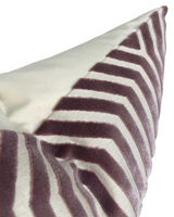 Close-up of a velvet pillow cover in lilac with a geometric zigzag pattern on an ivory background, highlighting its soft texture and clean stitching.