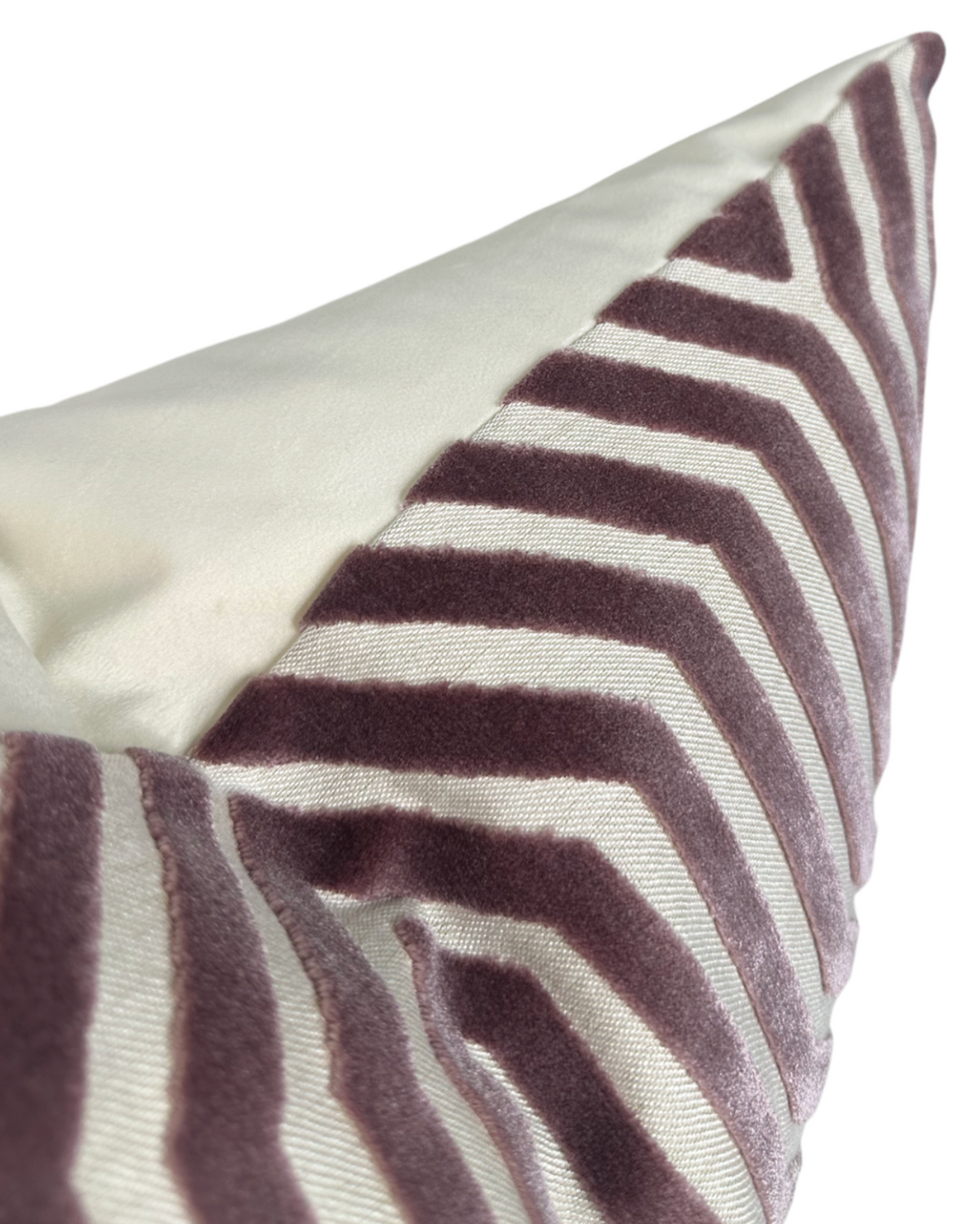 Close-up of a velvet pillow cover in lilac with a geometric zigzag pattern on an ivory background, highlighting its soft texture and clean stitching.