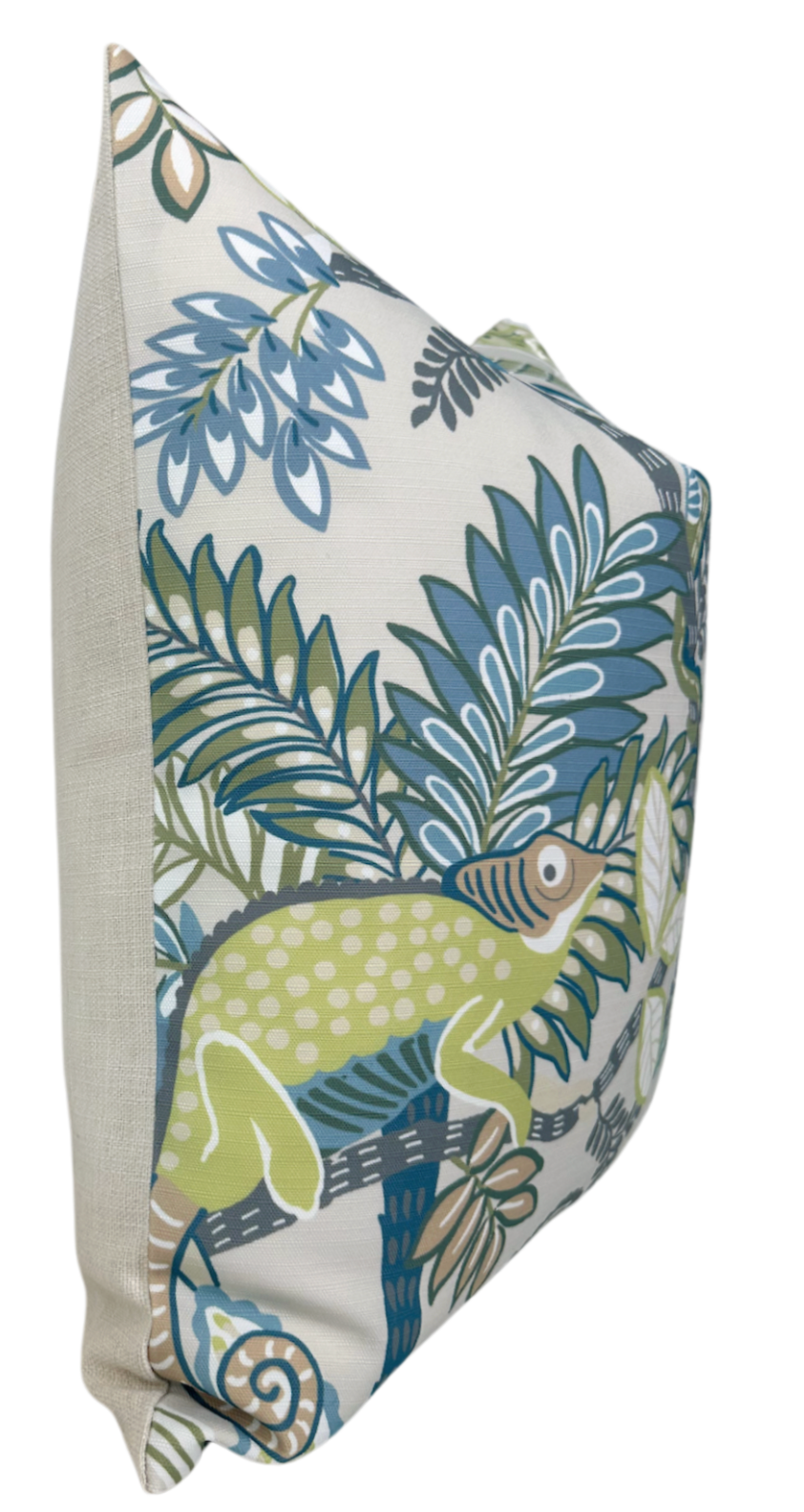 Square pillow with beige sides featuring a green lizard and blue and green tropical leaf pattern on a white background, shown from a side angle.