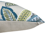 Cream-colored pillow corner with a zipper, featuring a patterned fabric top with green, blue, and gray stylized leaf designs against a white background.