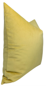 Yellow velvet pillow cover with a smooth, soft texture and subtle shading along its edges, shown angled against a white background.