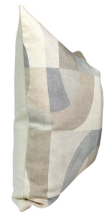 Square pillow cover featuring an abstract geometric pattern in soft beige, gray, and parchment tones, displayed from a side angle showing its plush texture.