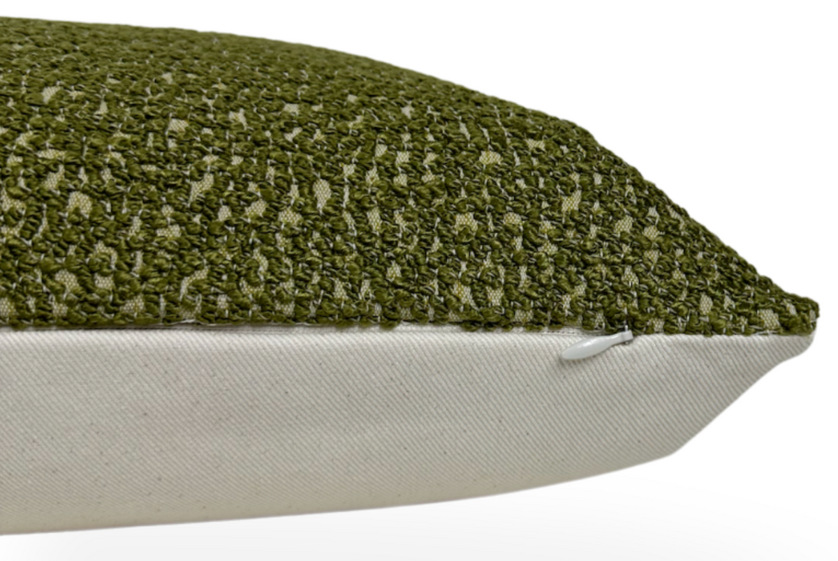 Close-up side view of a Serra Pillow Cover in chive green with textured knit fabric on top and smooth beige fabric on the bottom, featuring a concealed zipper.