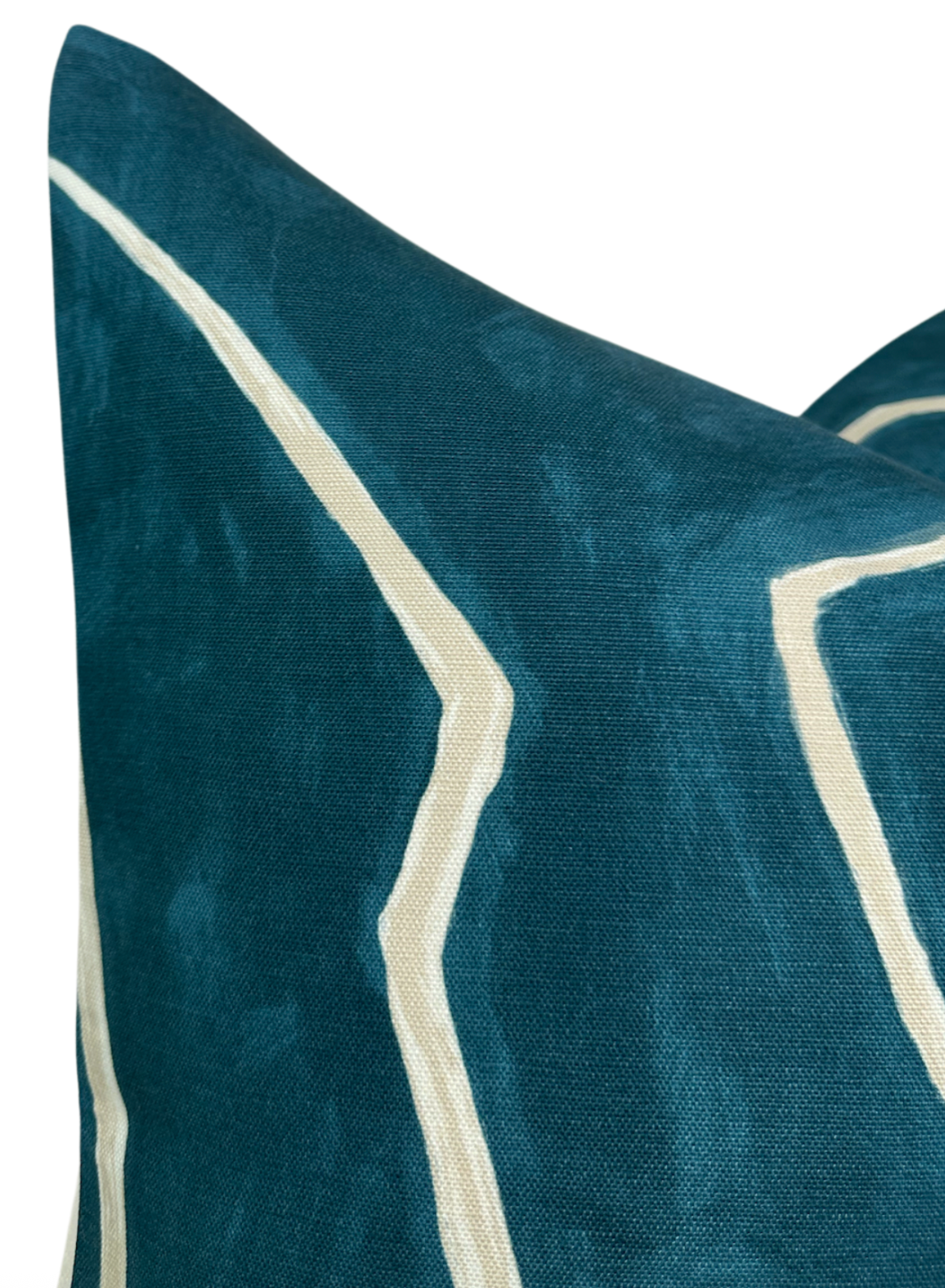 Close-up of teal pillow cover with an off-white abstract line pattern, featuring a soft textured fabric and sharp corner detail.
