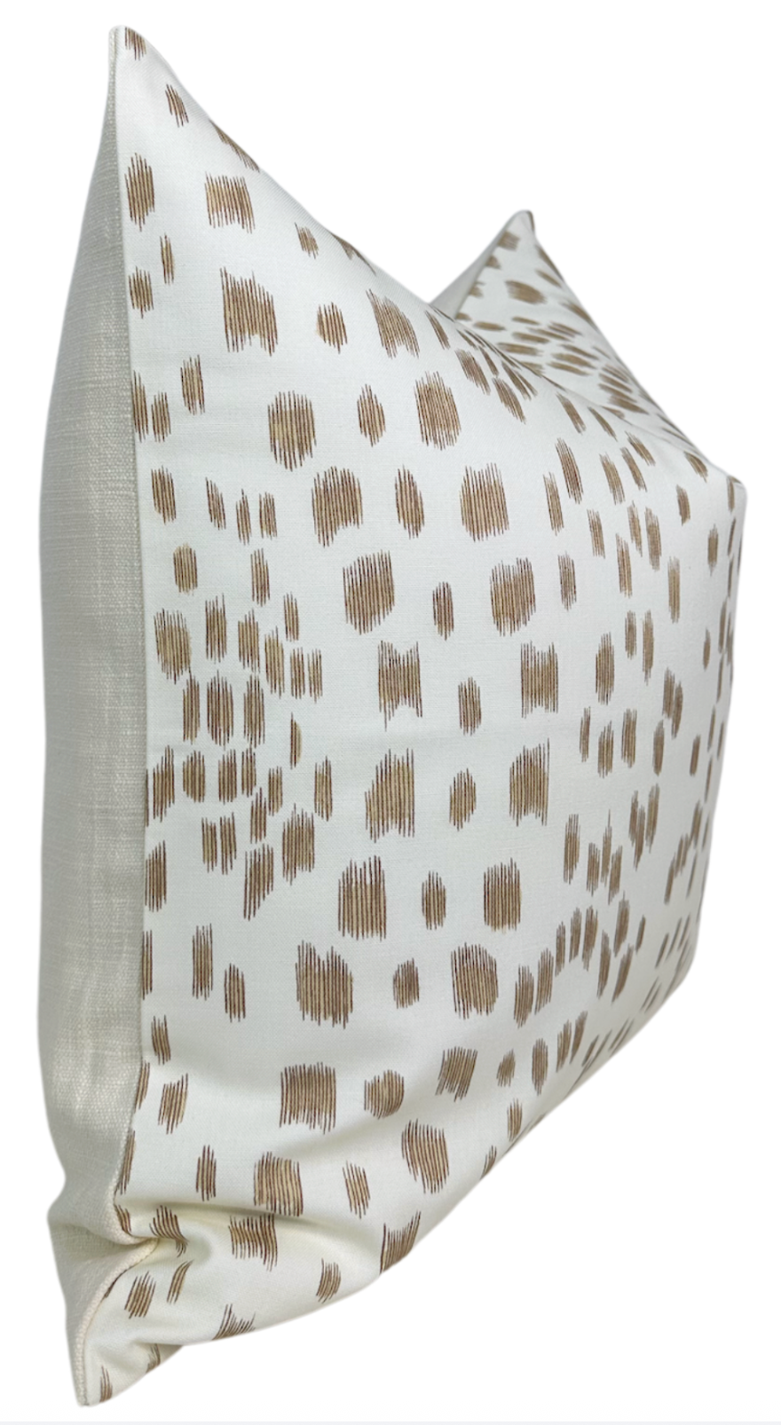 Rectangular pillow cover with beige abstract brushstroke pattern on cream fabric, shown from a side angle highlighting its plump, smooth texture.